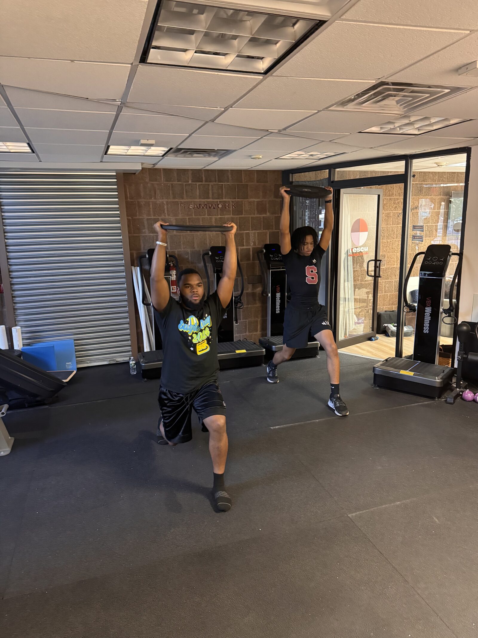 Overhead plate lunges — strength and stability circuit